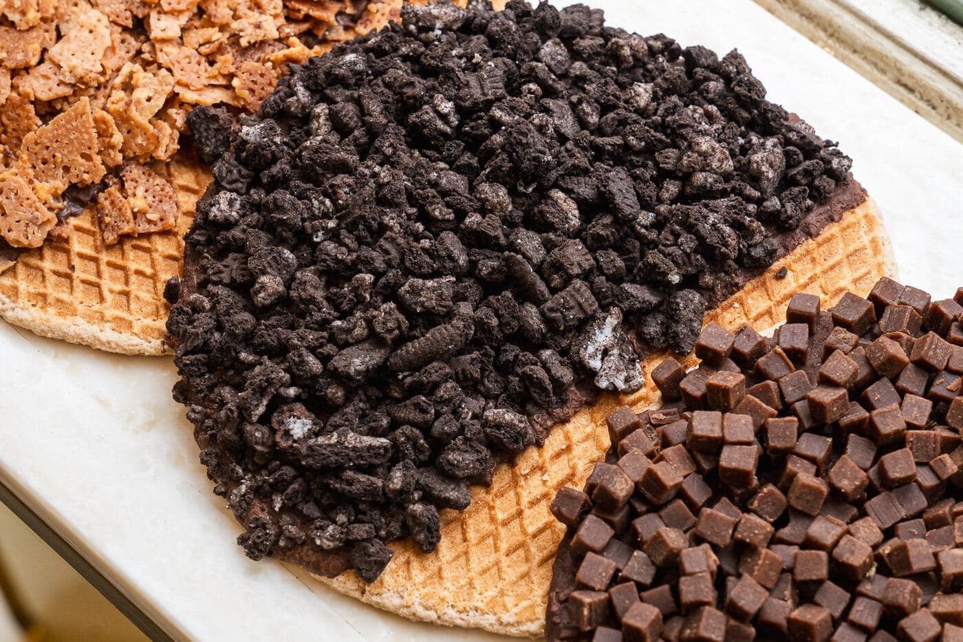Close-up of Melly's stroopwafels topped with Oreo, fudge and Biscoff in the shop case