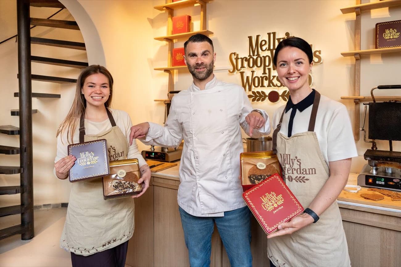 Two guests and the host at Melly's workshop in Amsterdam holding the gift boxes with the stroopwafels they made